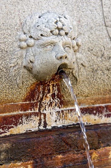 Putto, gargoyle with rusty red discoloration at the Neptune Fountain