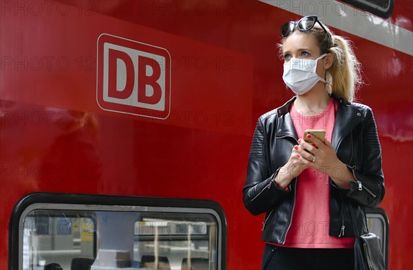 Woman with face mask, waiting for train