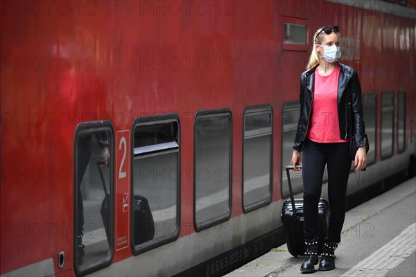 Woman with face mask, waiting for train