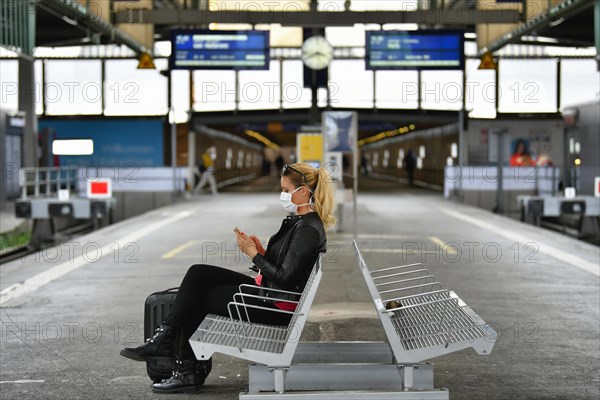 Woman with face mask, waiting for train