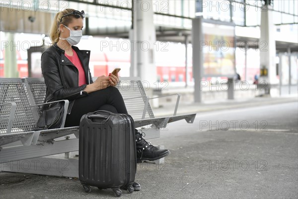 Woman with face mask, waiting for train