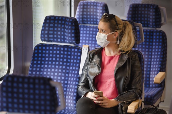 Woman with a face mask, sitting in Zug