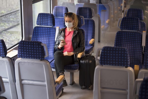 Woman with a face mask, sitting in Zug