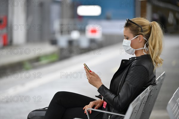 Woman with face mask, waiting for train