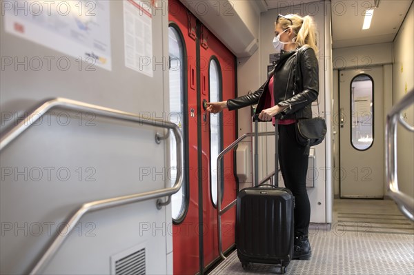 Woman with face mask, standing in train