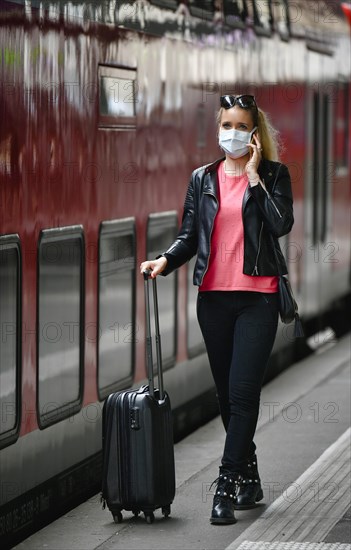 Woman with face mask, waiting for train