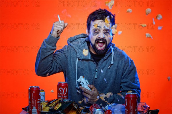 Young man with snacks and gamepad