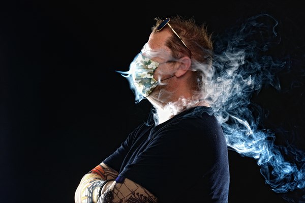 Man with face mask smoking cigarette