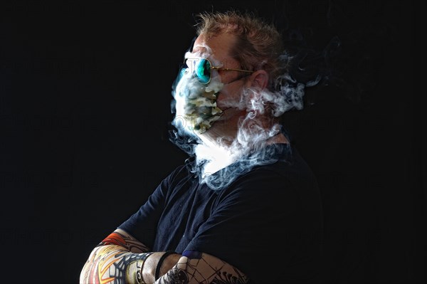 Man with face mask smoking cigarette