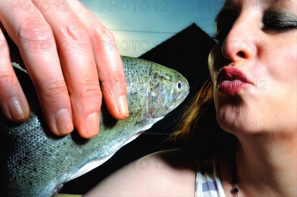 Woman kissing a fish