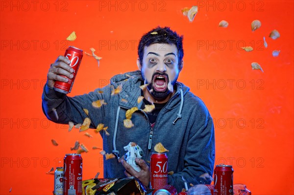 Young man with snacks and gamepad