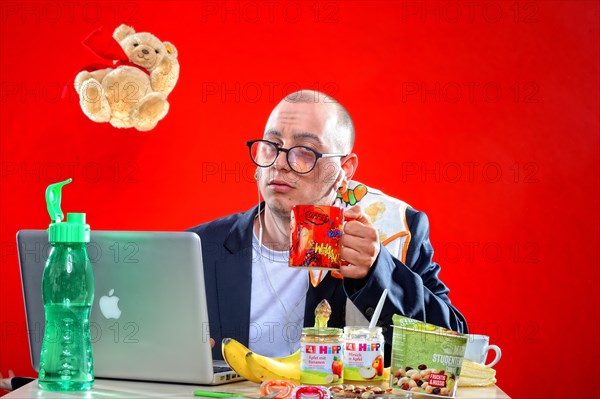 Young man with snacks in front of notebook