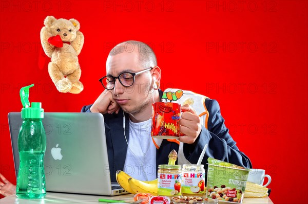 Young man with snacks in front of notebook