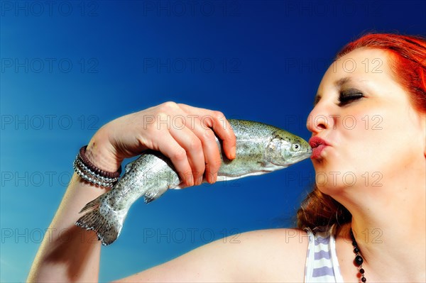 Woman kissing a fish