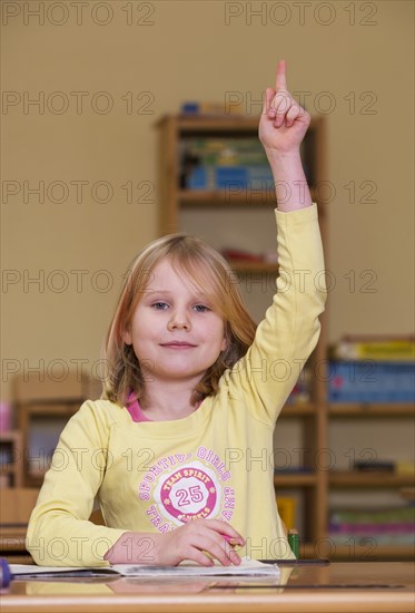 Pupil sitting in a classroom and reporting for class