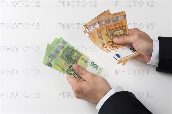 Businessman with 50 and 100 euro banknotes in his hand