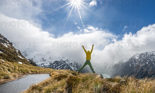 Hiker jumps into the air with outstretched arms