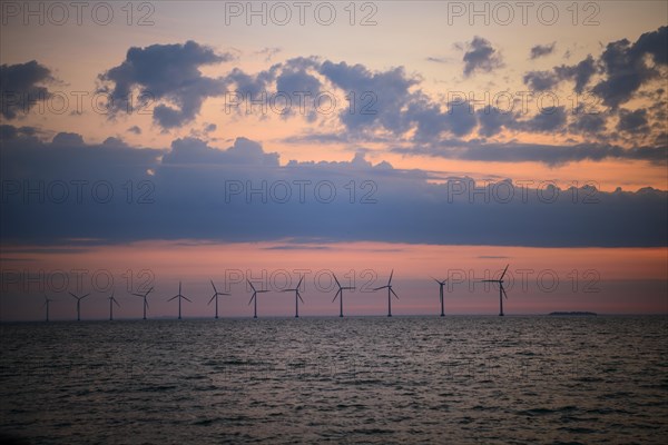 View from Amager beach to wind turbines in the sea at sunrise