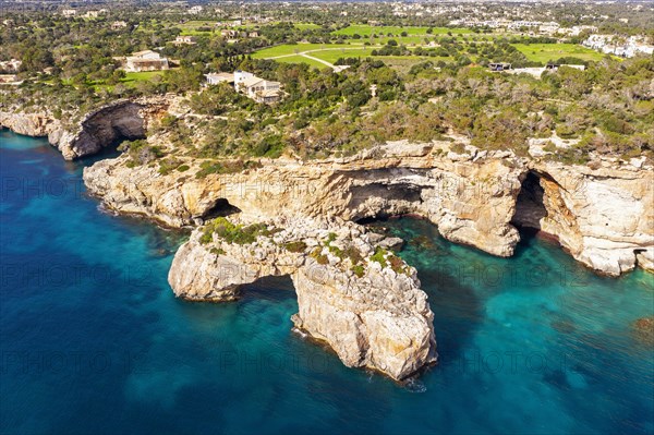 Steep coast with rock gate Es Pontas in the sea