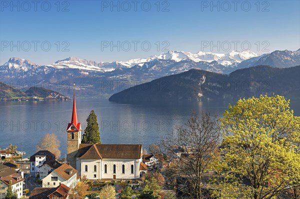 Holiday destination on Lake Lucerne with the parish church of St. Mary behind the snow-covered Alps