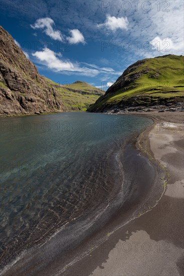 Sandy beach beach in bay surrounded by steep mountains