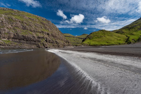 Sandy beach beach in bay surrounded by steep mountains