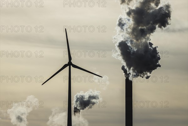 Wind turbine and smoking chimneys at the Uniper coal-fired power plant Scholven