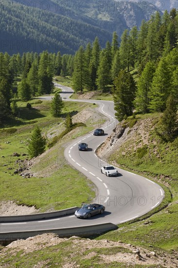 Sports cars on a winding Alpine road