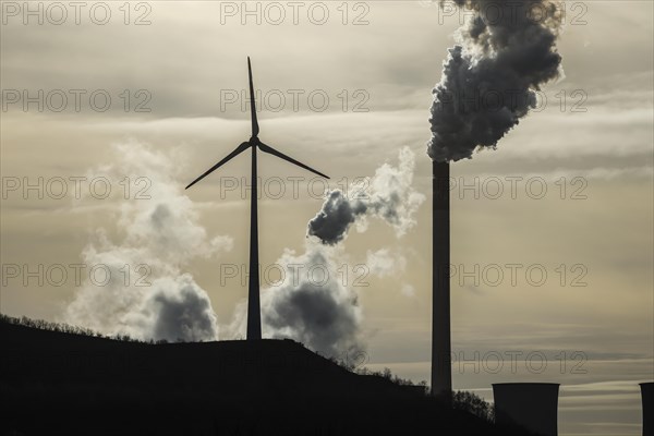 Wind turbine and smoking chimneys at the Uniper coal-fired power plant Scholven