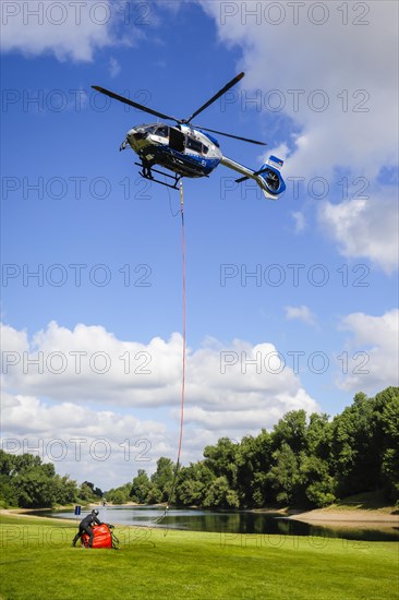 Police helicopter Airbus H 145 during exercise with fire water tank BAMBI BUCKET