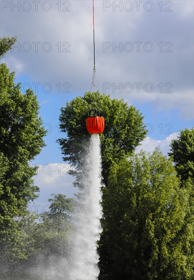 Police helicopter during exercise with fire water tank BAMBI BUCKET