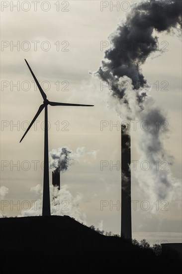 Wind turbine and smoking chimneys at the Uniper coal-fired power plant Scholven