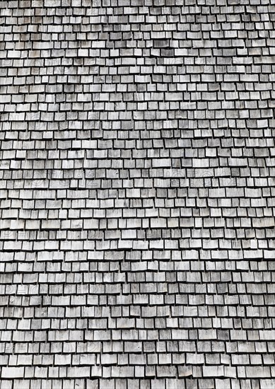 Facade of a wooden house with weathered wooden shingles