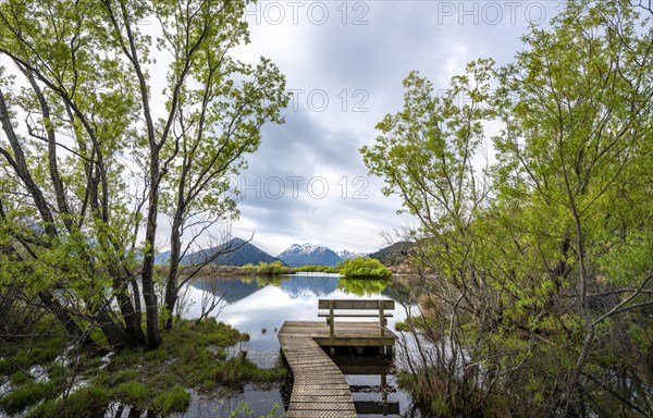 Jetty with wooden bench at the lake