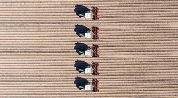 Aerial view of tractors ploughing fields in the agricultural sector