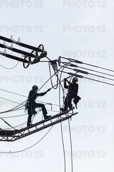 High voltage engineers working on high voltage pylons