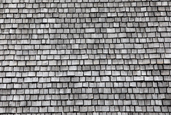 Facade of a wooden house with weathered wooden shingles