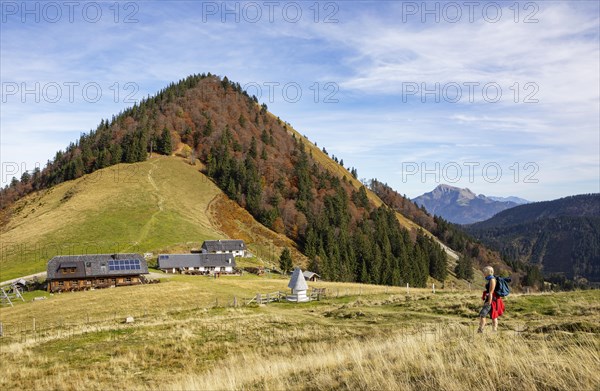 Hiker in front of the Doellererhuette and Lanznhuette on the Oberwiesalm