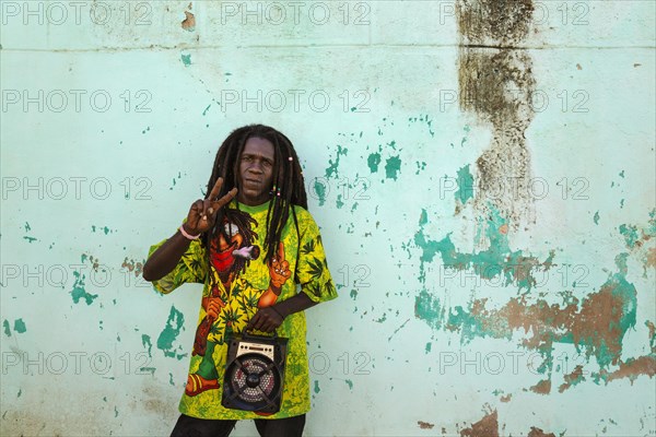 Rasta at a decayed wall of crumbling plaster