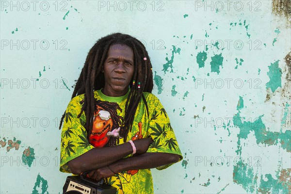 Rasta at a decayed wall of crumbling plaster