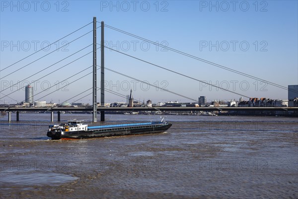 Freighters navigating at high water on the Rhine under the Rheinkniebruecke