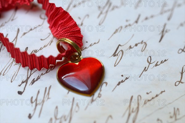 Pendant with heart on letter paper with old writing