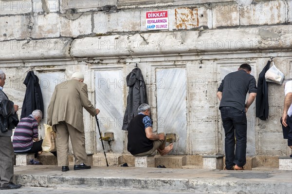 Men washing themselves at the cleaning fountain