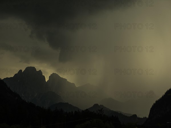 Thunderstorms and rain clouds over mountain peaks