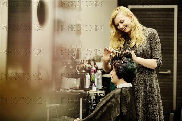 Hairdresser cuts the hair of a customer in a hairdressing salon