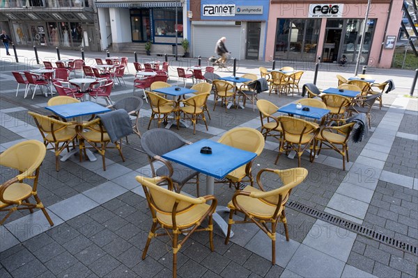 Empty tables and chairs in front of a restaurant