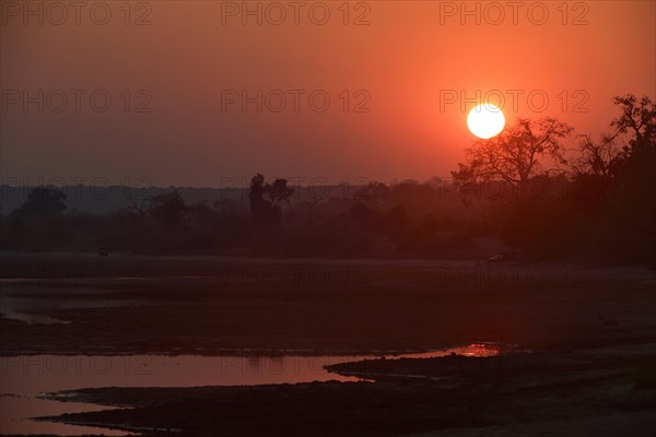 Sunrise safari vehicles along the Chobe River