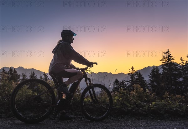 Silhouette of a female mountain biker in dusk