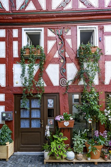 Small historic half-timbered house with painted carvings and flower decorations