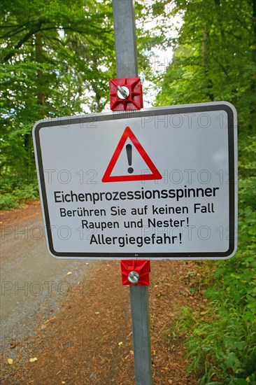 Warning sign on the forest road warns against the oak processionary moth